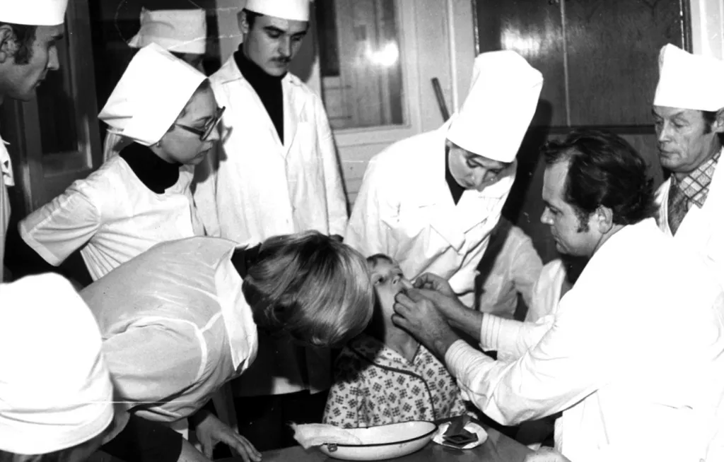 Борис Николаевич Давыдов с сотрудниками кафедры стоматологии детского возраста и студентами проводит осмотр маленького пациента после операции.jpg